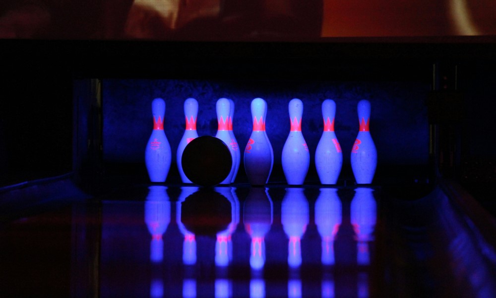 Bowling ball about to knock down pins